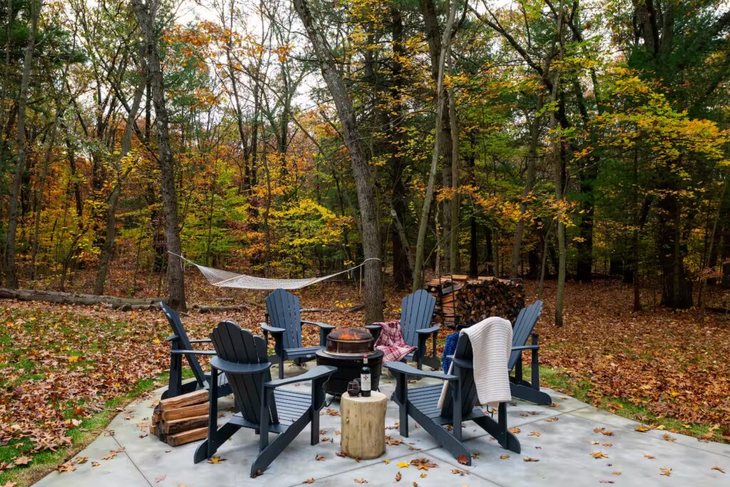 Fire pit circle with chairs in fallen leaves.