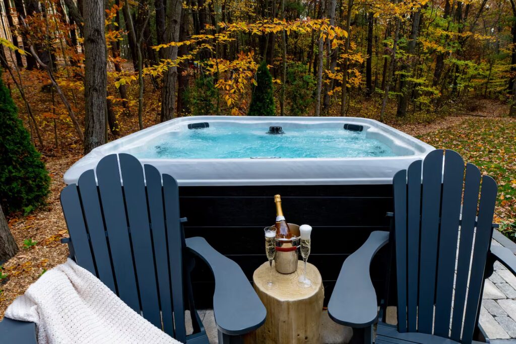 Hot tub ringed by chairs above the autumn woods.
