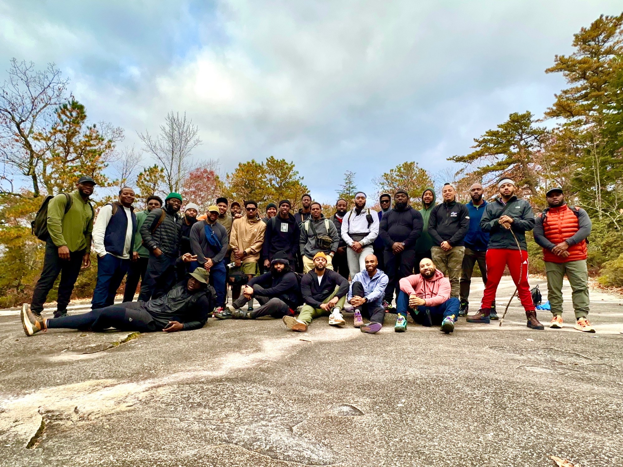 The men of The Healing gathered on a granite summit under autumn trees.